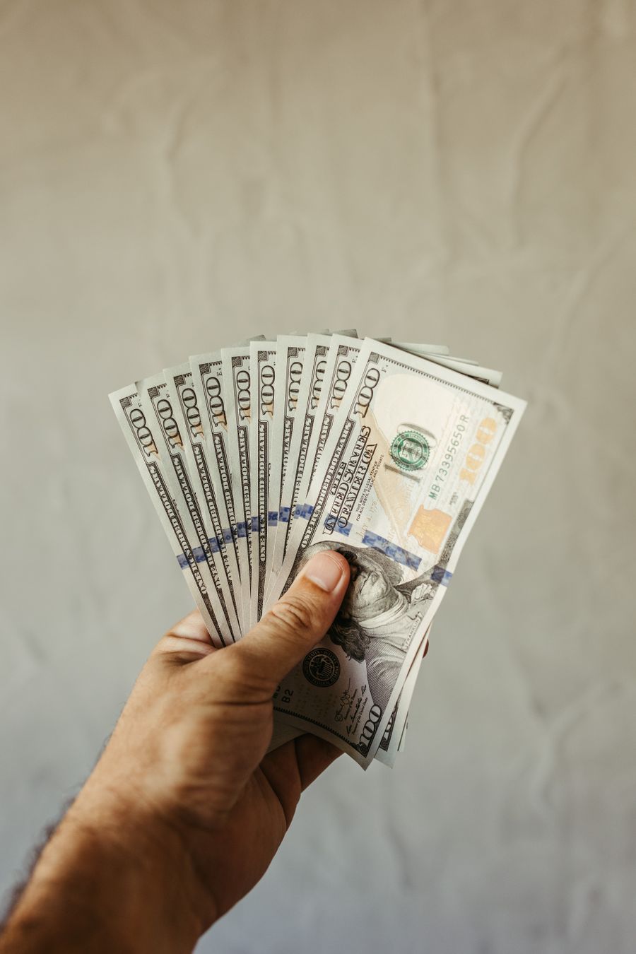 Pria memegang dompet berisi uang