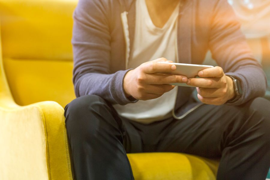 Pria dewasa menggunakan smartphone untuk mengakses permainan daring