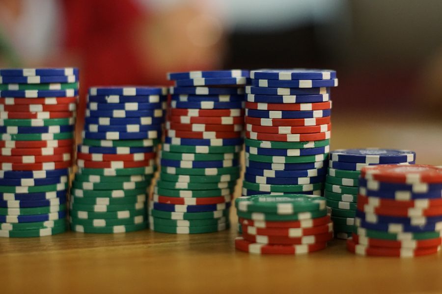 Tumpukan chip poker dan kartu remi di atas meja
